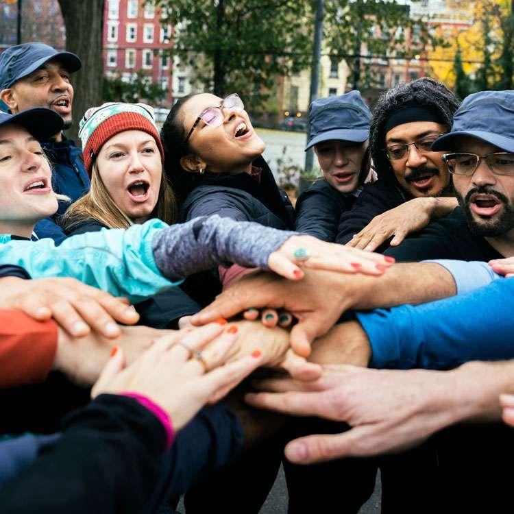 image of people putting their hands together in the center