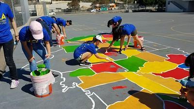 UCLA Volunteers Painting a map of the US on a playground