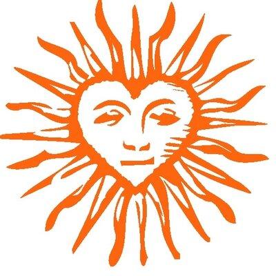 The Camp del Corazon logo shows an orange sun with it's center in the shape of a heart and containing the outlines of a face.