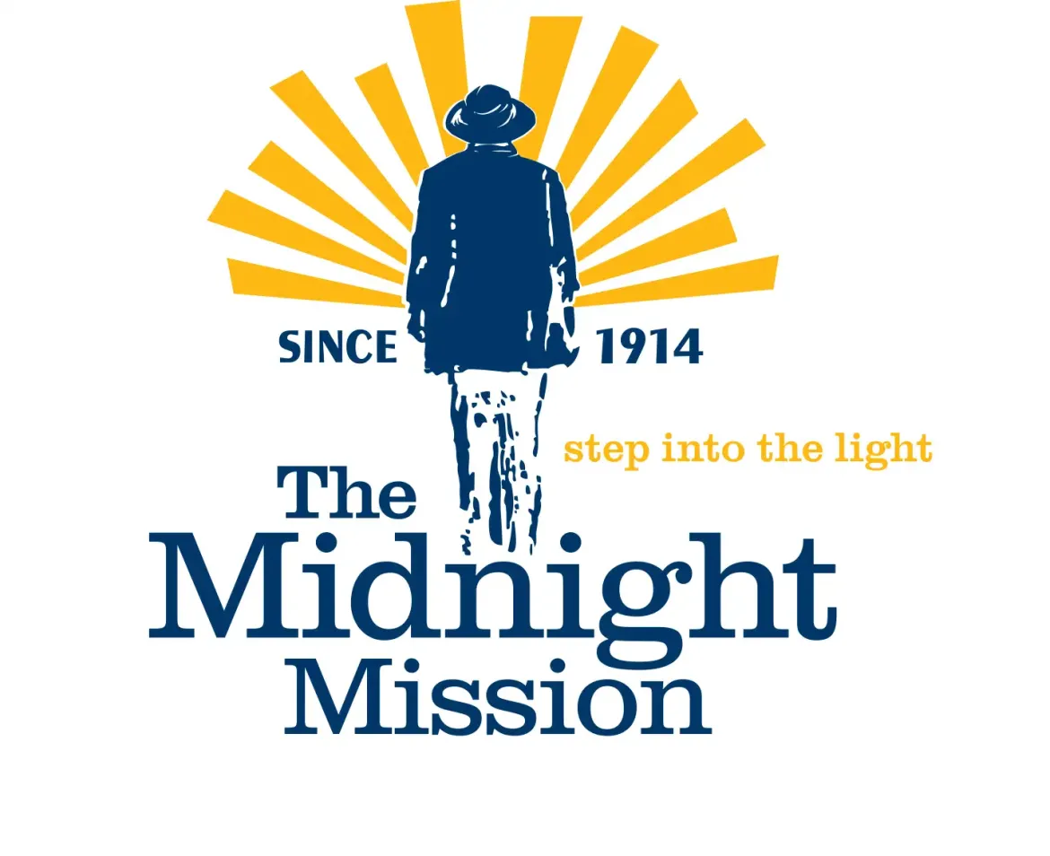 The logo depicts the back of a person walking towards the sunset. At the person's waist, the text reads in blue "SINCE 1914". Below the person in larger blue text reads "The Midnight Mission" and in yellow "step into the light".
