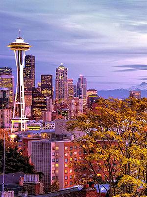The photo shows the Seattle skyline at dusk, featuring the Space Needle building.