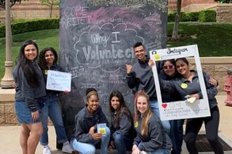 Group of Volunteers in front of a chalk wall  